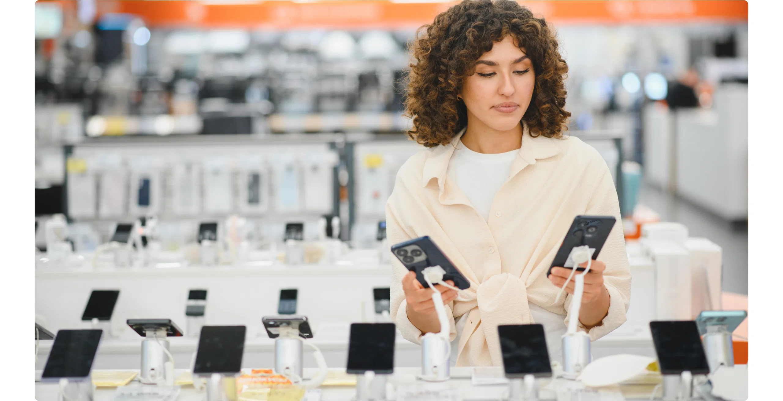Woman smiling while working on a laptop in an office setting.