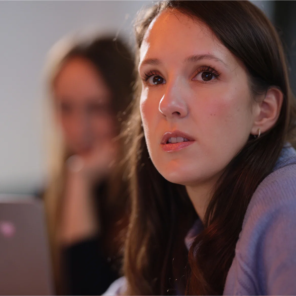 Woman listening attentively in a meeting setting.