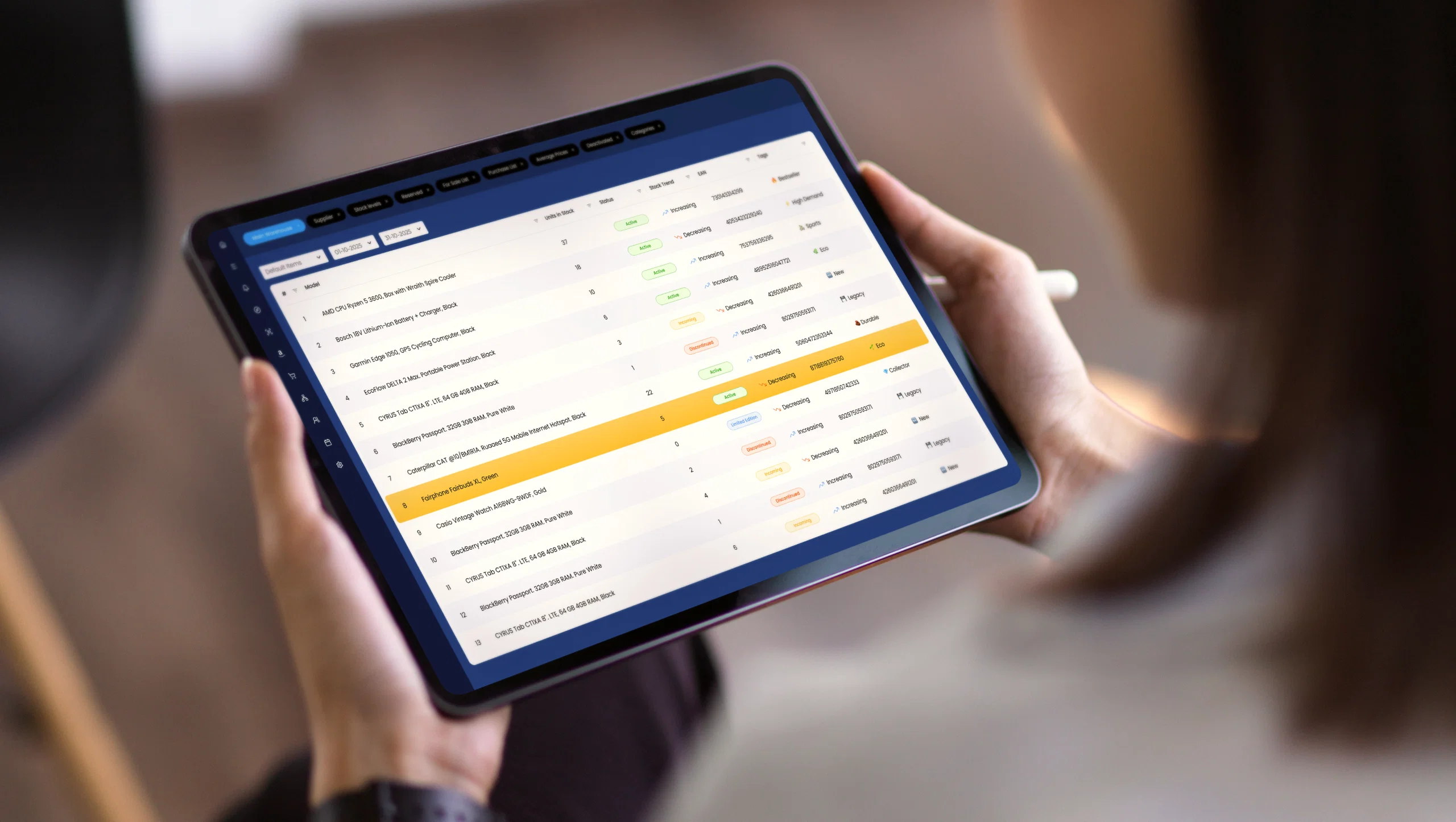 Person using a tablet to view a data management dashboard with a list of items and statuses.