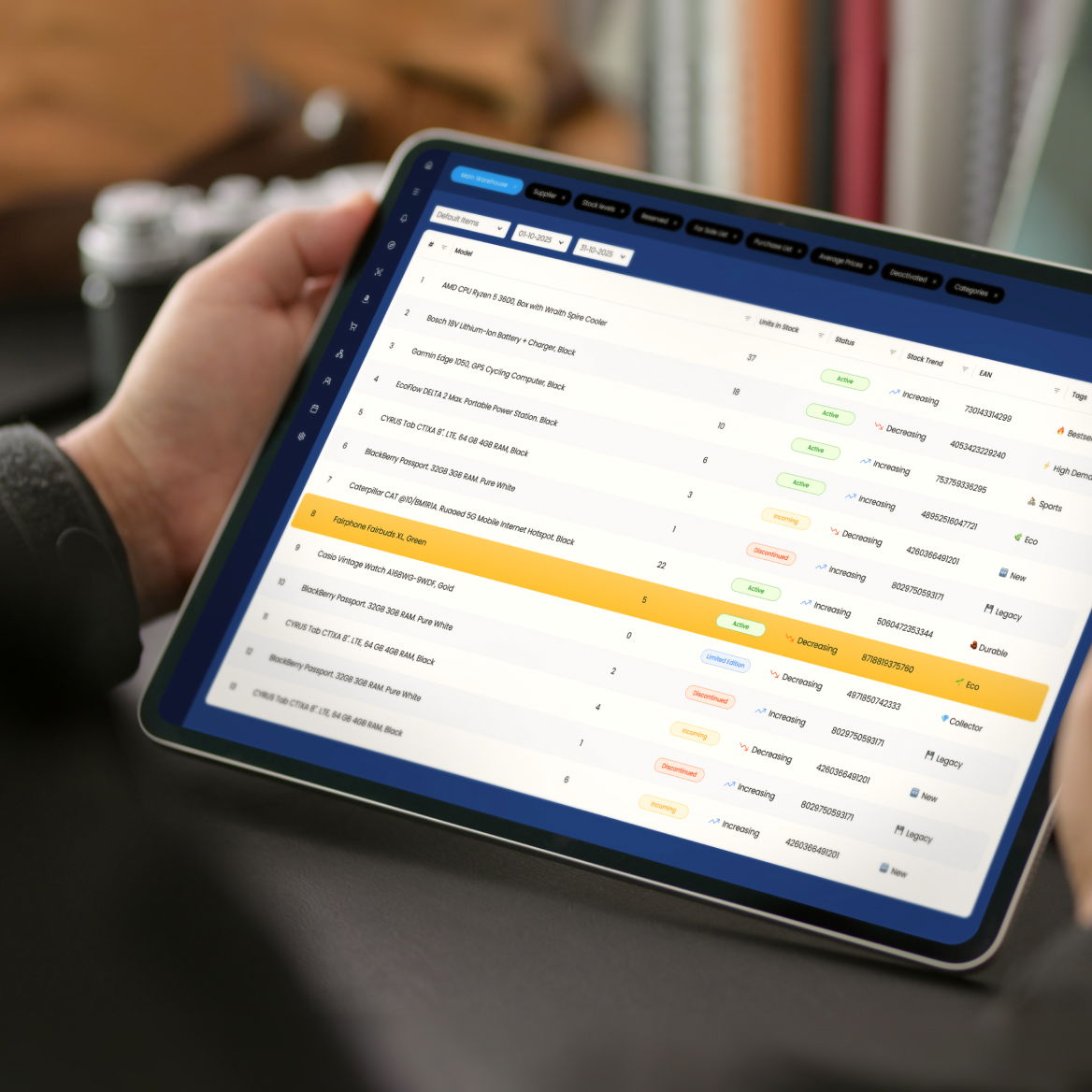 Person using a tablet to view a data management dashboard with a list of items and statuses.