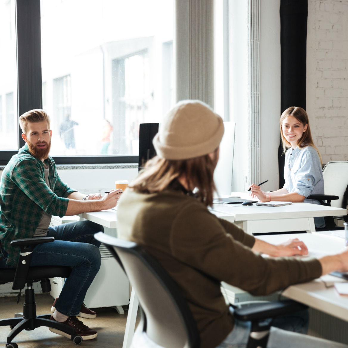 Team collaborating at desks in a creative open office space.